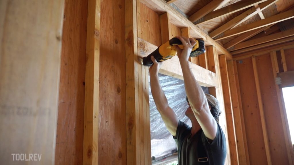 Man using DeWalt Flexvolt reciprocating saw to cut wood framing.
