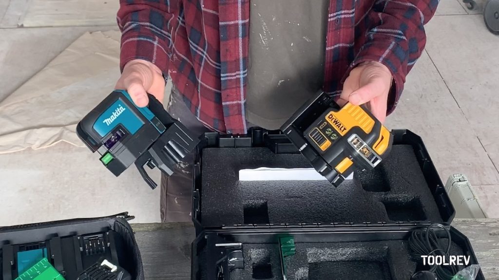 Man holding a Makita and a DeWalt laser level .