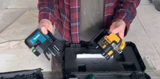 Man holding two laser levels .