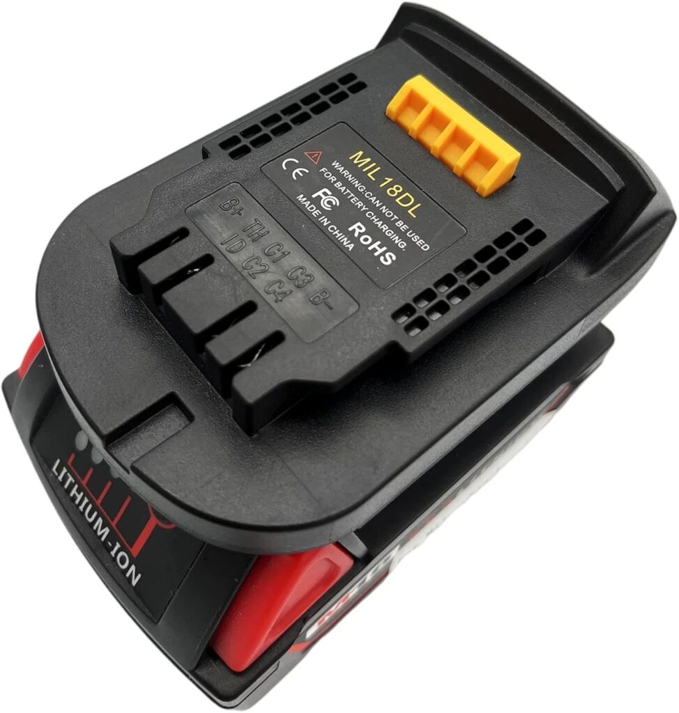 Battery adapter in black coloring with yellow tab attached atop a Milwaukee battery against a white background.