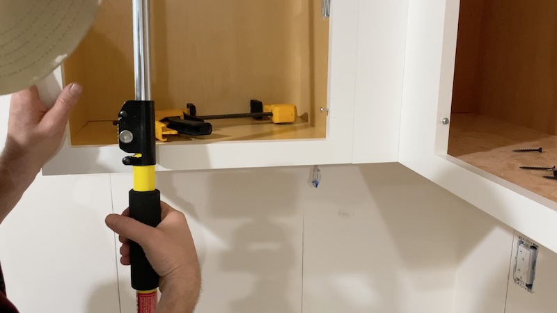 Task support rod holding up a kitchen cabinet.