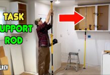 Task support rod holding up a kitchen cabinet during construction.