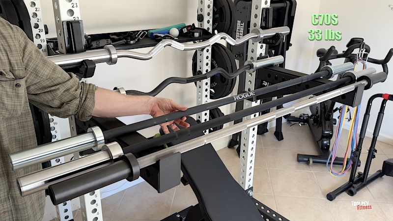 three short barbells shown on a weight lifting rack