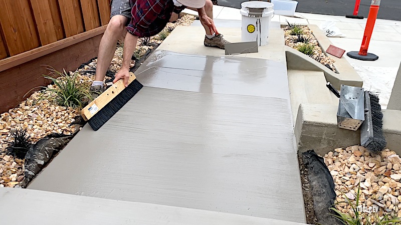worker broom finishing concrete