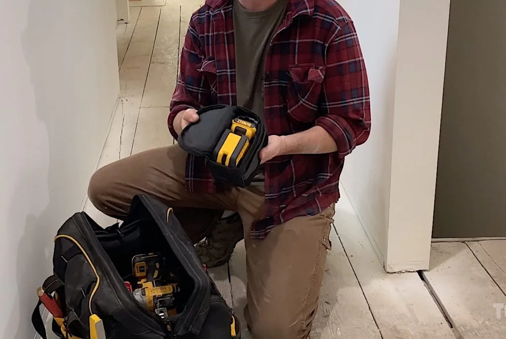 DeWalt laser level packed in a small pouch next to a tool bag DeWalt laser level packed in a small pouch next to a tool bag