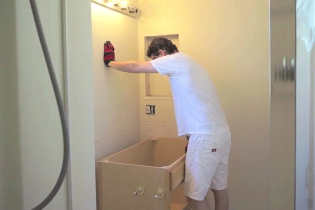 Pulling a bathroom vanity cabinet away from the wall Pulling a bathroom vanity cabinet away from the wall