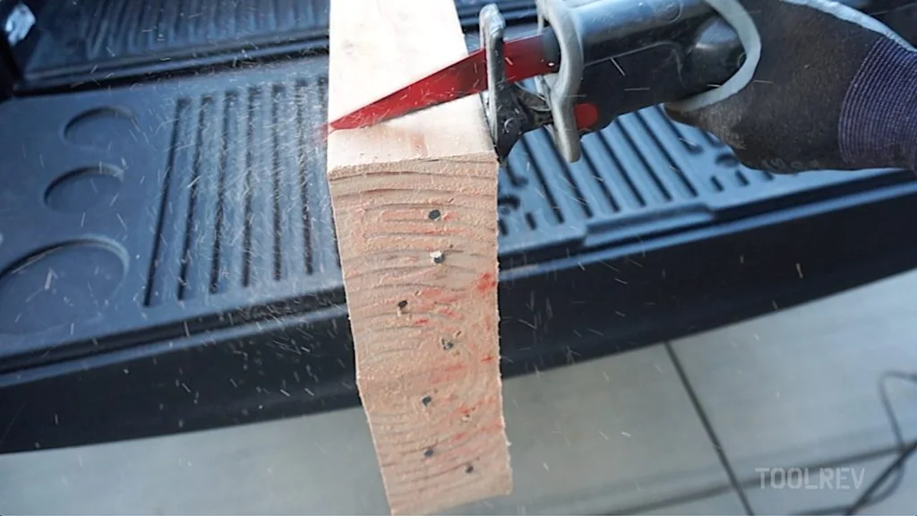 Makita reciprocating saw cutting a 2x4, sawdust in the air Makita reciprocating saw cutting a 2x4, sawdust in the air